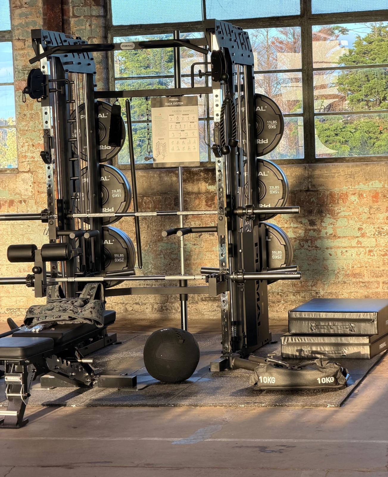 Fitness equipment photographed against sunlit brick and factory windows