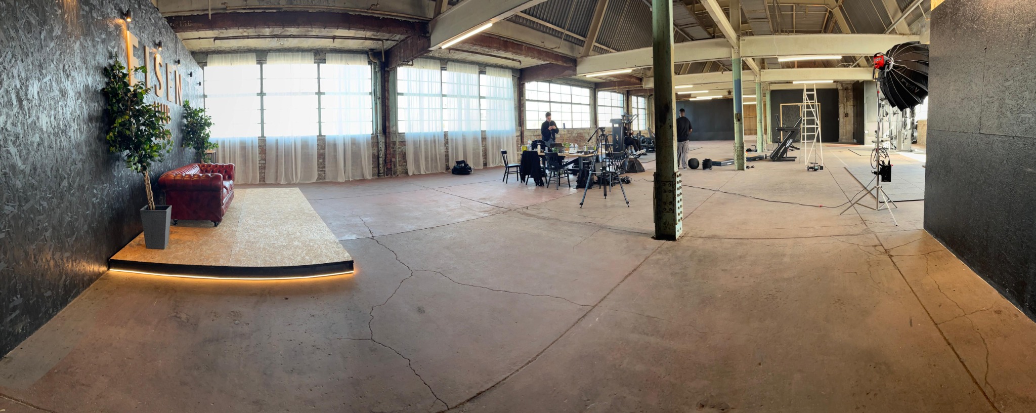 Wide view across the studio during a shoot, showing equipment and crew areas